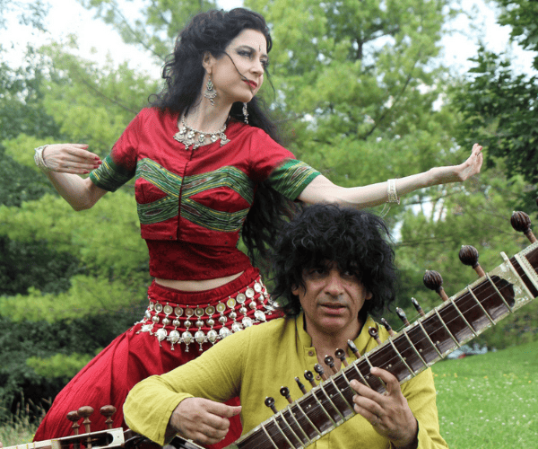 Genvieve Bealieu dances while Anwar Kurshid plays the sitar in an outdoor setting