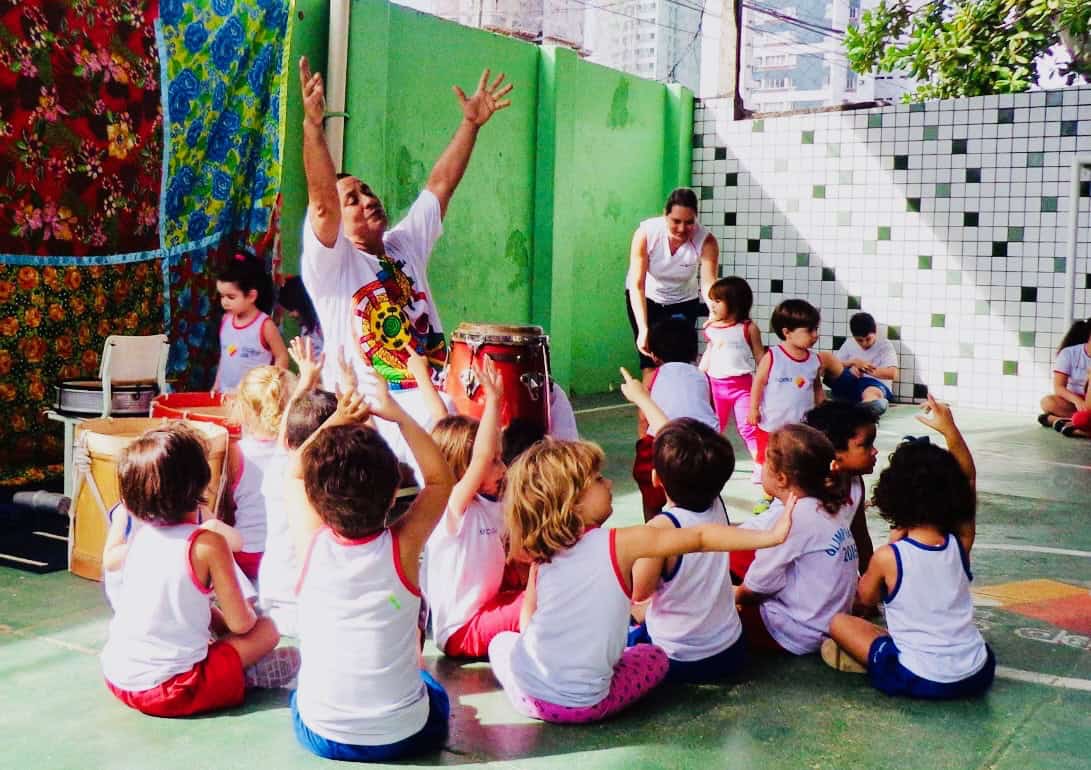 Mestre Sérgio with excited kids in a circle