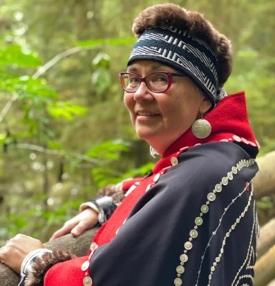 Kung Jaadee pictured standing in the forest wearing traditional Haida Regalia