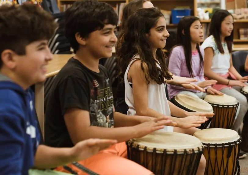 Students playing djembe drums