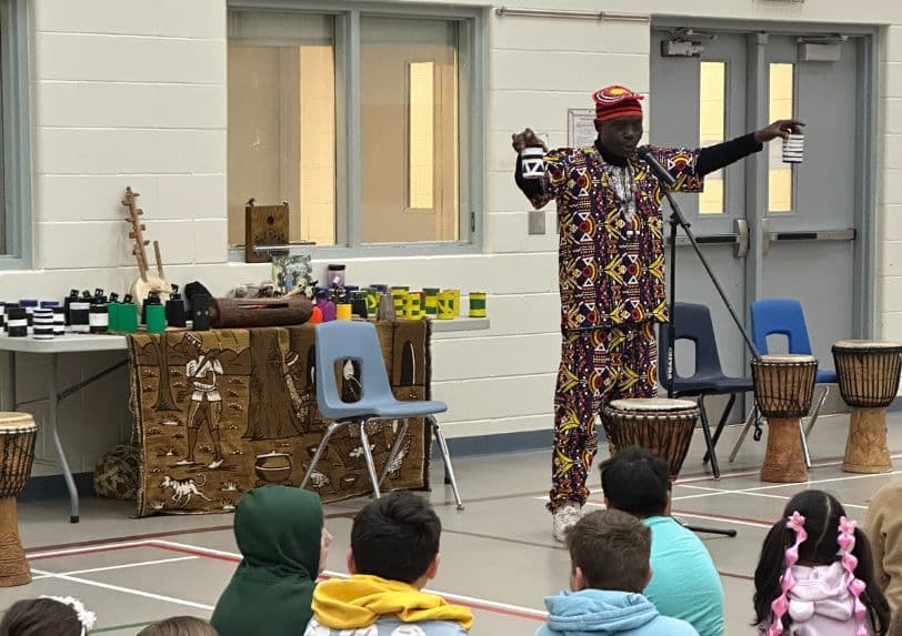 Njacko Backo performs at a school for a student audience 