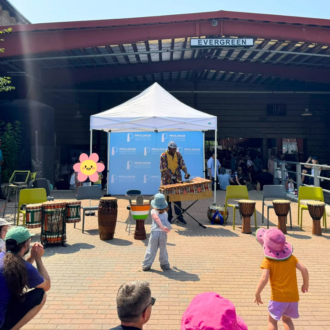 Kids dancing to percussion music being played by Fana Soro