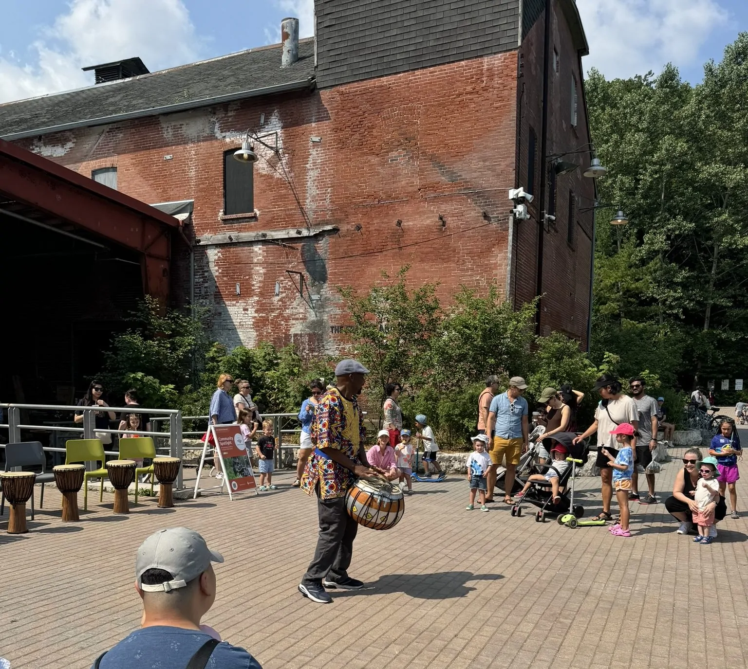 Fana Soro plays a bara drum for a crowd gathered at Evergreen Brick Works