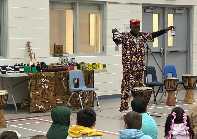 Njacko Backo performs at a school for a student audience 
