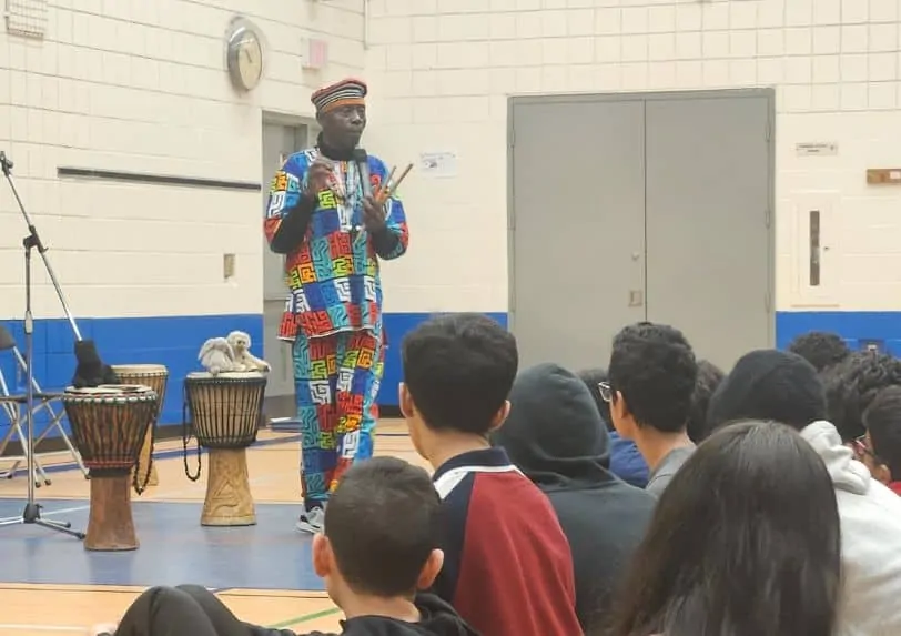 Njacko Backo performs for students in a gym